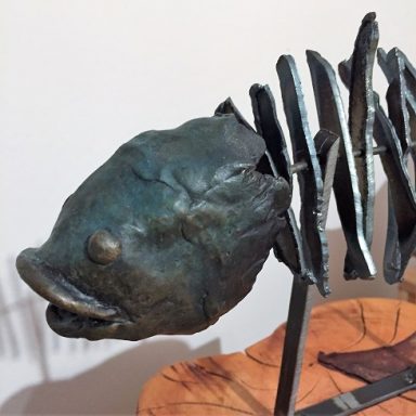 Bronzene Fischskulptur mit markanten Gräten und realistischer Kopfstruktur.